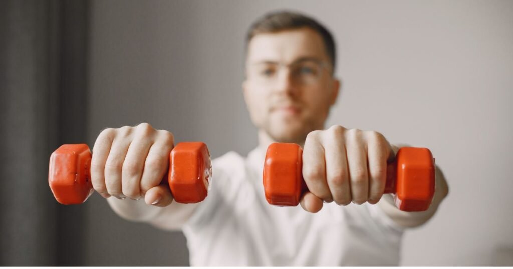 "Person lifting dumbbells during a strength workout to lose weight without losing muscle and improve upper body strength."

